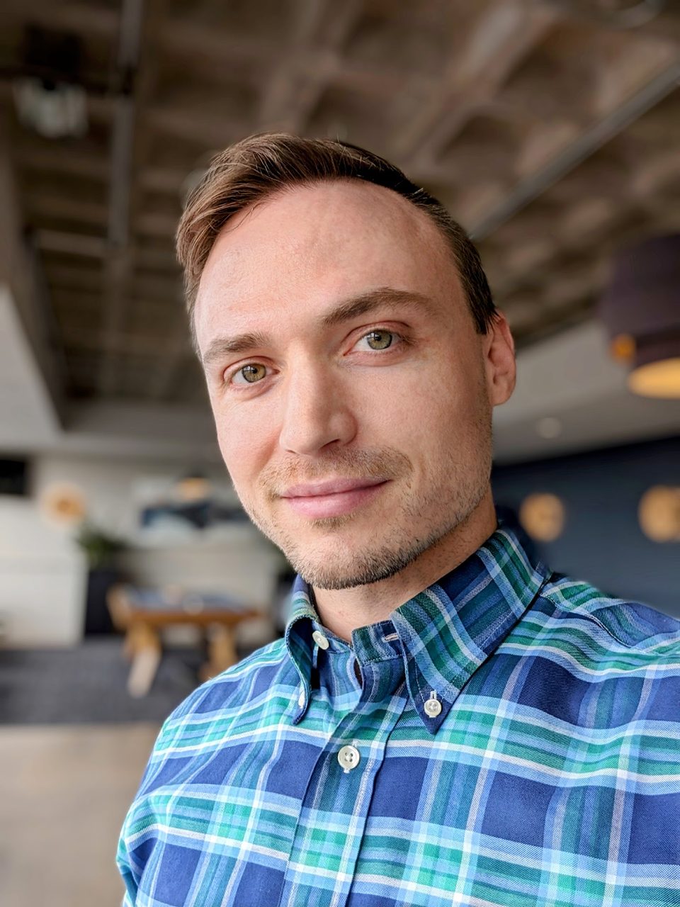 Sean Hobin, head and shoulders: short brown hair, a slight smile and a blue and green plaid shirt.